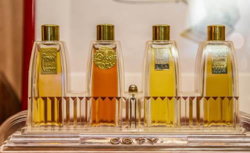three bottles of oil sitting on top of a shelf at Hôtel Mercure Paris Suresnes Longchamp in Suresnes