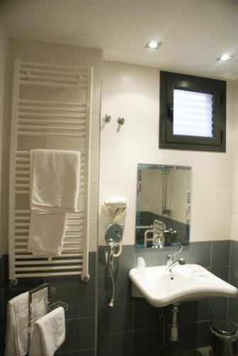 a bathroom with a sink and a mirror at Hospedium Hotel Vittoria Colonna in Medina de Rioseco