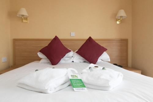 Una cama con dos toallas encima. en Queens Hotel, en Blackpool