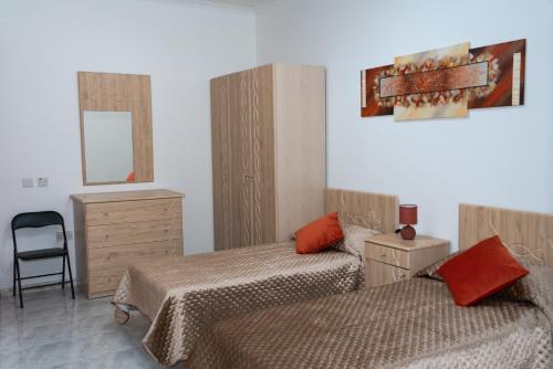 een slaapkamer met 2 bedden, een dressoir en een spiegel bij Sea-View 3 bedroom Apartment - Sleeps 8 in Marsaskala