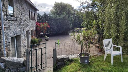 a white chair sitting in front of a house at maison individuelle au calme sur l'Aubrac in Recoules-dʼAubrac