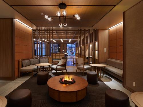 a lobby with a fireplace and tables and chairs at Sapporo Granbell Hotel in Sapporo