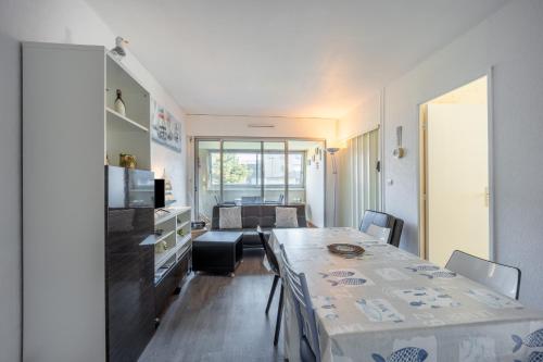 une cuisine et un salon avec une table et des chaises dans l'établissement Le Pavois - appartement à 50 mètres de la mer, à Bernières-sur-Mer
