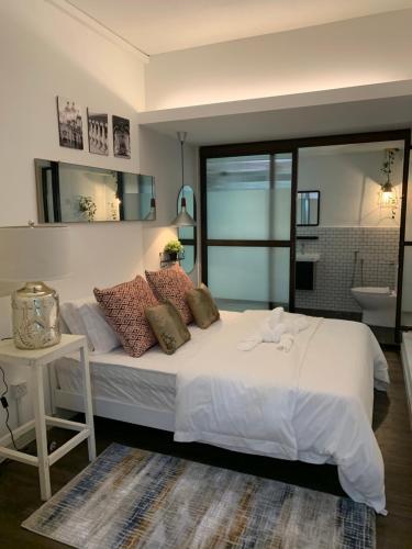 a bedroom with a large white bed and a bathroom at MyBed Homestay in Padang Besar