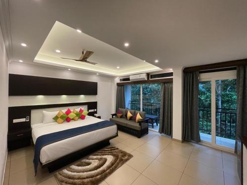 a bedroom with a king sized bed and a couch at AMUSE VISTA RESORTS AND SPA in Anachal