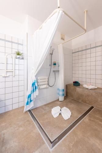 a bathroom with a shower with a curtain on the floor at Hotel Nibelungen Hof in Xanten