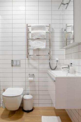 a white bathroom with a toilet and a sink at FOREST PALANGA RESORT in Palanga