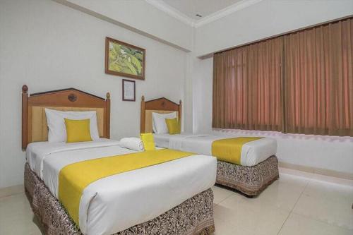 Un ou plusieurs lits dans un hébergement de l'établissement Hotel Yehezkiel Surapati Mitra RedDoorz