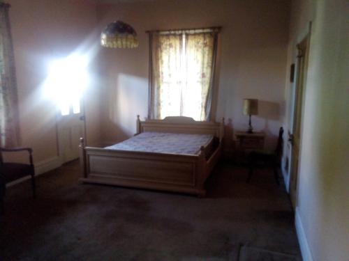 1 dormitorio con cama y ventana en Sylvia Lodge A step back in time pet friendly Homestay en Orbost