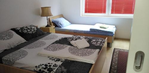 a small room with two beds and a window at TEA Apartmani in Bajina Bašta