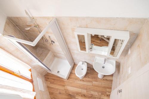 a bathroom with a sink and a toilet and a mirror at Valery Apartments Alghero in Alghero