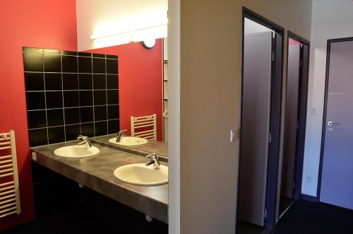 a bathroom with two sinks and a mirror at Auberge de Jeunesse de Morlaix in Morlaix