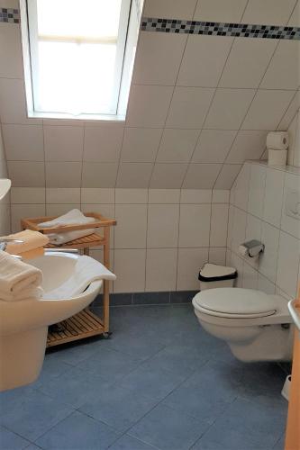 a bathroom with a toilet and a sink at Landhaus Braband Ferienwohnungen - Cuxhavener Straße 96 in Cuxhaven