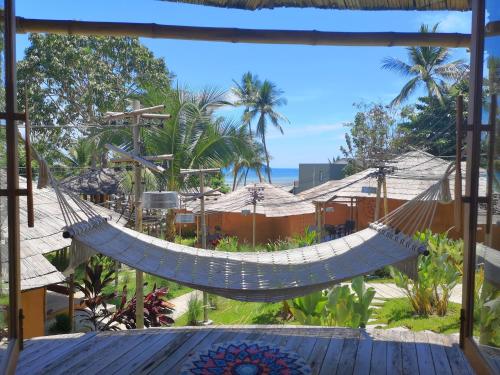 a hammock on a porch with a view of the beach at The Mud - Eco Hotel in Ban Bang Po