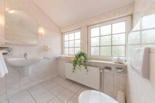 a white bathroom with a sink and a toilet at Landhaus Braband in Cuxhaven