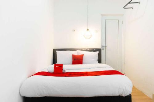 a bedroom with a large bed with red pillows at RedDoorz near Sam Poo Kong 3 Semarang in Kalibanteng-lor