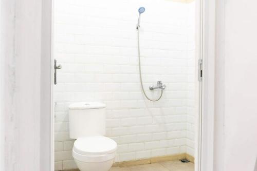 a white bathroom with a toilet and a shower at RedDoorz near Sam Poo Kong 3 Semarang in Kalibanteng-lor