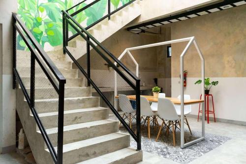 a staircase with a table and chairs and a dining room at RedDoorz near Sam Poo Kong 3 Semarang in Kalibanteng-lor
