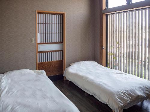 香取市的住宿－小江戶旅舍，一间卧室设有一张床和一个大窗户