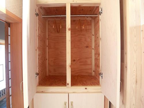 um armário de madeira com portas de vidro num quarto em HOSTEL Co-EDO em Katori