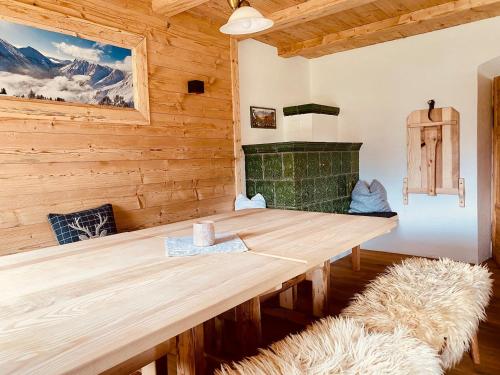 drewniany stół w pokoju z kominkiem w obiekcie Ferienhaus Tuxerhof w mieście Achenkirch