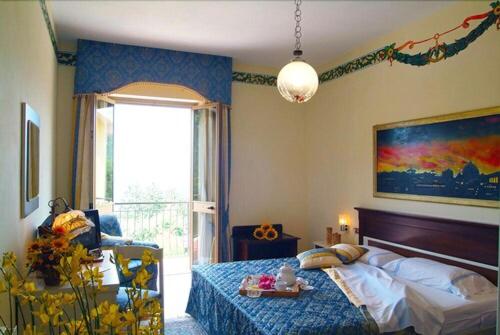 a bedroom with a bed and a large window at Albergo Ristorante Belvedere in Minucciano