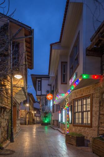 une rue vide la nuit avec des lumières de Noël sur les bâtiments dans l'établissement Delight Deluxe Aparts, à Antalya