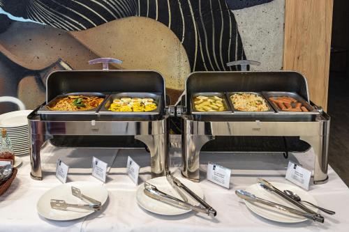 two trays of food on top of a table at Optima Collection Mural Lviv in Lviv