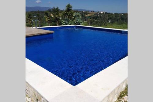 ein Pool mit blauem Wasser in einem Haus in der Unterkunft Quinta dos Malhadais, Figueira - Farm house in Portimão