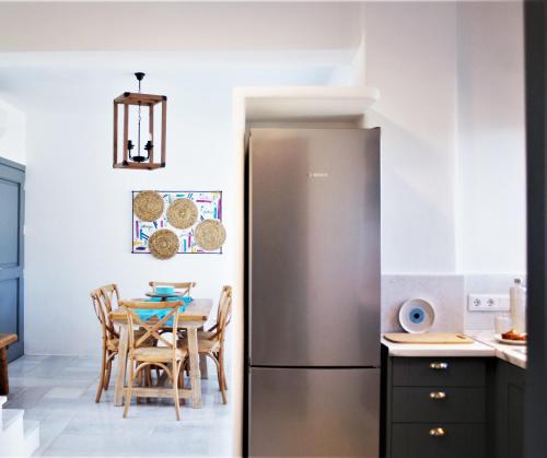 a stainless steel refrigerator in a kitchen with a table at Krotiri View Paros in Krotiri