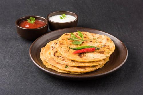un plato de tortillas con chile y salsa en StayVista at Horizon 4BHK with Breakfast & Valley view, en Kasauli