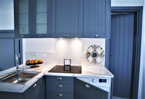 a kitchen with blue cabinets and a sink at Krotiri View Paros in Krotiri