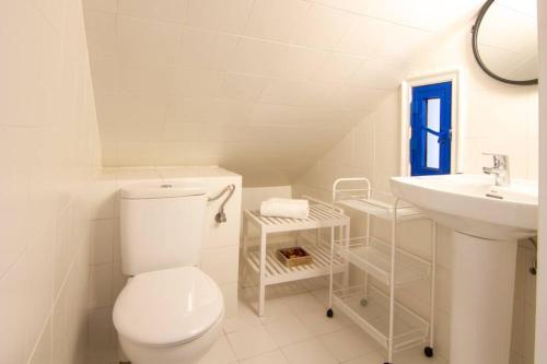 a white bathroom with a toilet and a sink at Bungalow en Pasito V15 in Pasito Blanco
