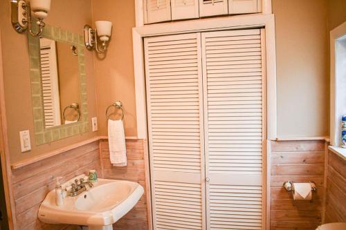 ein Badezimmer mit einem Waschbecken, einem WC und einem Spiegel in der Unterkunft Brook Road Cabin in Goshen