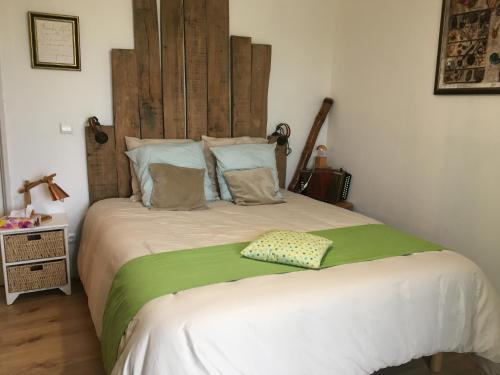 a bedroom with a large bed with a wooden headboard at Maison Dougnac in Fleurance