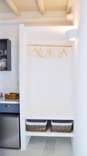 a kitchen with white walls and a shelf with baskets at Krotiri View Paros in Krotiri