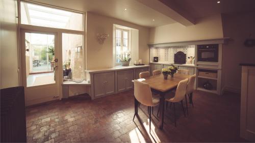 a kitchen with a table and chairs in a kitchen at La Villa Celestine in Chablis