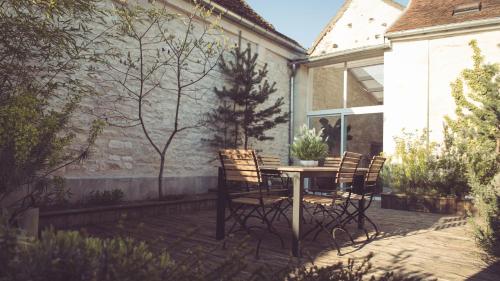 a patio with a table and chairs in a backyard at La Villa Celestine in Chablis