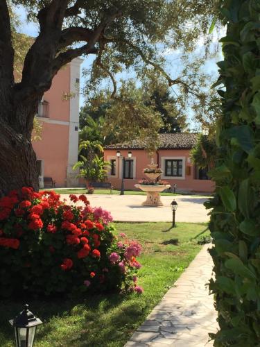 a park with flowers and a tree and a building at Hotel Lady Lusya in Syracuse