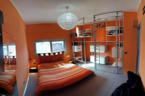 a bedroom with orange walls and bunk beds in it at House'n'Kite in Nurachi