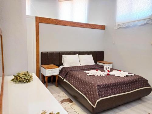 a bedroom with a bed with two stuffed animals on it at Hotel Palme Dalyan in Dalyan