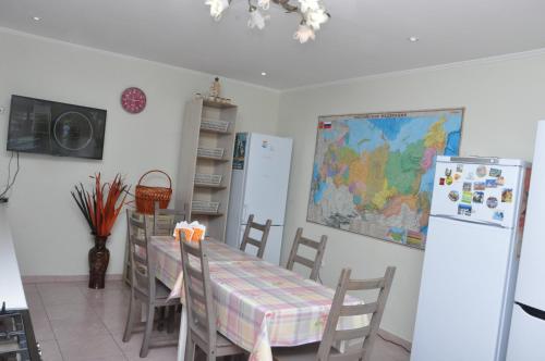a kitchen with a table and chairs and a refrigerator at Zorka Guest House in Adler