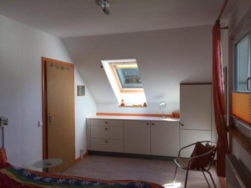 eine Küche mit einem Fenster, einem Waschbecken und einem Stuhl in der Unterkunft Ferienwohnung Sonnengelb in Schwielowsee