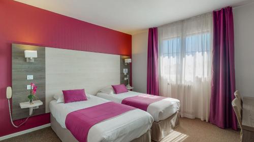 2 Betten in einem Hotelzimmer mit lila Wänden in der Unterkunft Hotel Akena Toulouse Le Prado - Proche Zénith in Toulouse