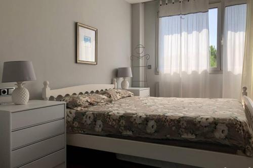 a bedroom with a bed and a dresser and a window at NEREIDES 31 in Platja d'Aro