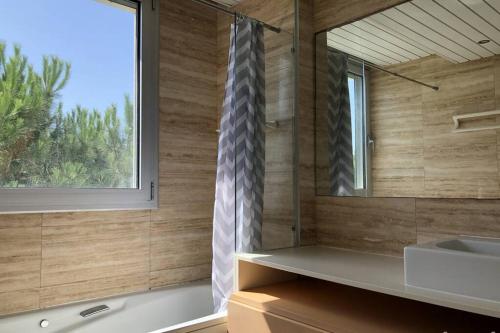 a bathroom with a tub and a sink and a window at NEREIDES 31 in Platja d'Aro