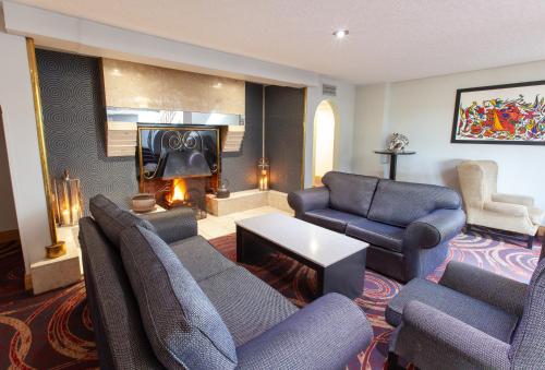 a living room with couches chairs and a fireplace at Best Western Plus White Horse Hotel in Derry Londonderry