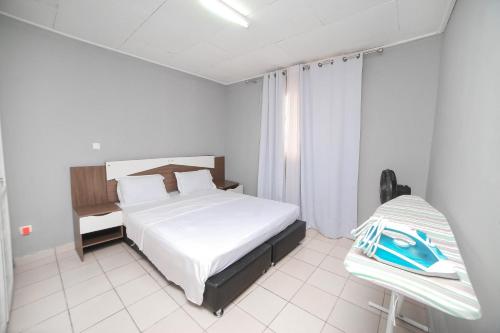 Ένα ή περισσότερα κρεβάτια σε δωμάτιο στο Les Residences de la providence-Appart Hotel Obobogo