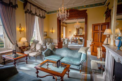 a living room with a blue couch and a table at Kilworth House Hotel and Theatre in Lutterworth