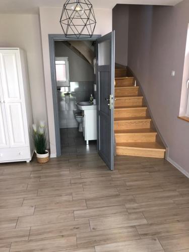 a hallway with a staircase and a bathroom with a sink at Lawendowe Domki 70m in Międzywodzie
